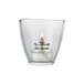 A Sterno clear glass votive candle holder with a lit flame inside.