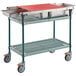 A Metro Prepmate Butcher Prep Cart with metal trays on a metal shelf.