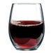 An Arcoroc Perfection stemless wine glass filled with red wine on a table.
