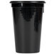 A black plastic cup in a San Jamar Wireworks cup and straw organizer.