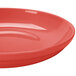 A CAC red salad / pasta bowl on a red surface.