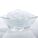 A bowl of Manitowoc flake ice in a clear bowl on a white background.