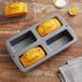 A Wilton 4-compartment mini loaf pan with four slices of bread in it.