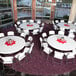 A Lifetime white plastic round folding table with white plastic chairs.