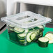 A Carlisle clear plastic container lid with sliced cucumbers inside.