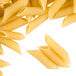 A pile of Regal penne rigate pasta on a white background.