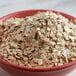A bowl of Bob's Red Mill gluten-free whole grain oat flakes on a table.
