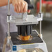 A hand uses a Vollrath 8 section wedger to cut a potato.