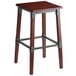 A Lancaster Table & Seating rustic industrial wooden bar stool with metal legs.