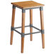 A Lancaster Table & Seating backless bar stool with a wooden seat and metal legs.