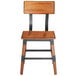 A Lancaster Table & Seating rustic industrial dining side chair with a wooden seat and backrest and metal legs.