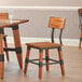 A Lancaster Table & Seating rustic wooden dining chair with a metal frame.