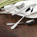 A Walco Windsor Supreme stainless steel dinner knife on a plate with a fork and spoon.