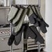 A rack with SafeMitt flame retardant oven mitts hanging on it.