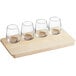 An Acopa Natural Flight Tray with four 6 oz. stemless wine glasses.