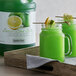 A jar of Narvon Lemon Lime Slushy concentrate with a green drink inside, garnished with a lime slice.