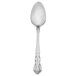 A silver Walco Discretion dessert spoon with a handle.