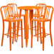 An orange metal bar table with four orange stools.