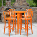 An orange Flash Furniture table and chair set on an outdoor patio.