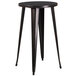 A round black metal bar height table with legs.