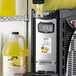 A beverage dispenser with a machine filled with yellow Narvon Pina Colada slushy.
