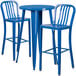 A blue metal round bar height table with two blue metal stools with vertical slat backs.