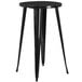 A Flash Furniture black metal table with a round top and legs with two black metal stools with vertical slat backs.