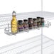A Regency chrome shelving rack with spices and bottles on it.