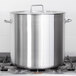A Vollrath stainless steel pot cover on a large silver pot.