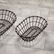 Two American Metalcraft bronze oval wire baskets on a wood surface.