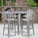 A Flash Furniture silver metal bar height table with four vertical slat back stools.