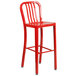 A red metal bar stool with a seat.