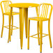 A yellow metal bar table with two yellow chairs.