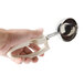 A hand holding a Zeroll Ivory ice cream scoop with a squeeze handle.