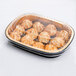 A Durable Packaging black and gold aluminum foil container with food inside.