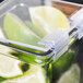 A Cal-Mil hinged hard plastic lid on a glass container of limes.