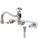 A T&S chrome wall mount faucet with two handles and an 8" swing nozzle hose.