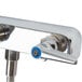 A T&S chrome wall mount faucet with blue handles and an 8" swing nozzle.