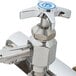A T&S chrome wall mounted faucet with a blue spray valve handle.