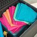 A stack of towels in a gray plastic container.