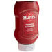 A red plastic squeeze bottle of Hunts tomato ketchup with a white label.
