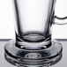 A close up of a Libbey clear glass Irish coffee mug with a handle on a table.