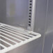 A white metal shelf inside a Turbo Air undercounter freezer.