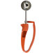 A close-up of a Zeroll red metal ice cream scoop with an orange handle.