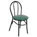 A black metal Lancaster Table & Seating hairpin chair with a green vinyl seat.