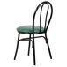 A Lancaster Table & Seating black metal hairpin chair with a green cushion.