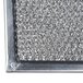 A close-up of a silver metal mesh filter with a small hole in it.