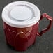 A red Dinex Fenwick mug with a white lid.