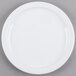 A white Cambro ceramic plate with a white rim on a gray surface.
