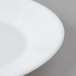 A close up of an Arcoroc white opal oval platter with a white rim.